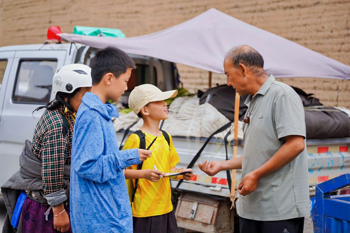 孩子们在村寨的集市上与当地老人交谈